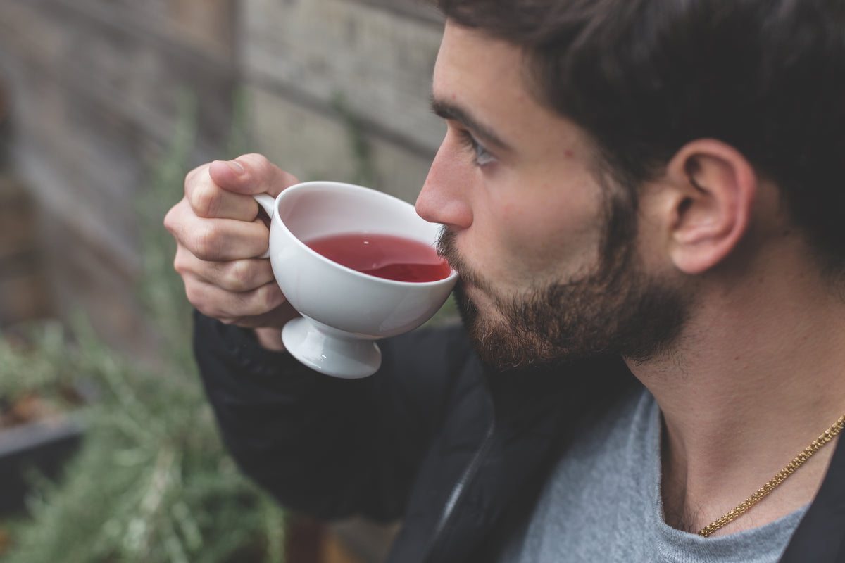 A person sipping a cup of herbal tea